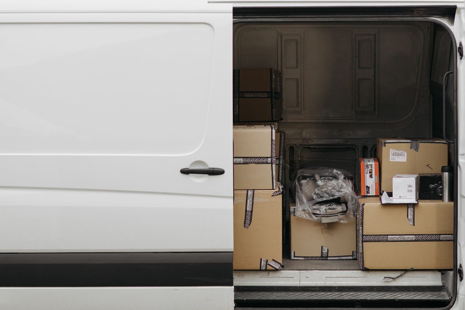 Camioneta de reparto abierta y llena de cajas lista para salir
